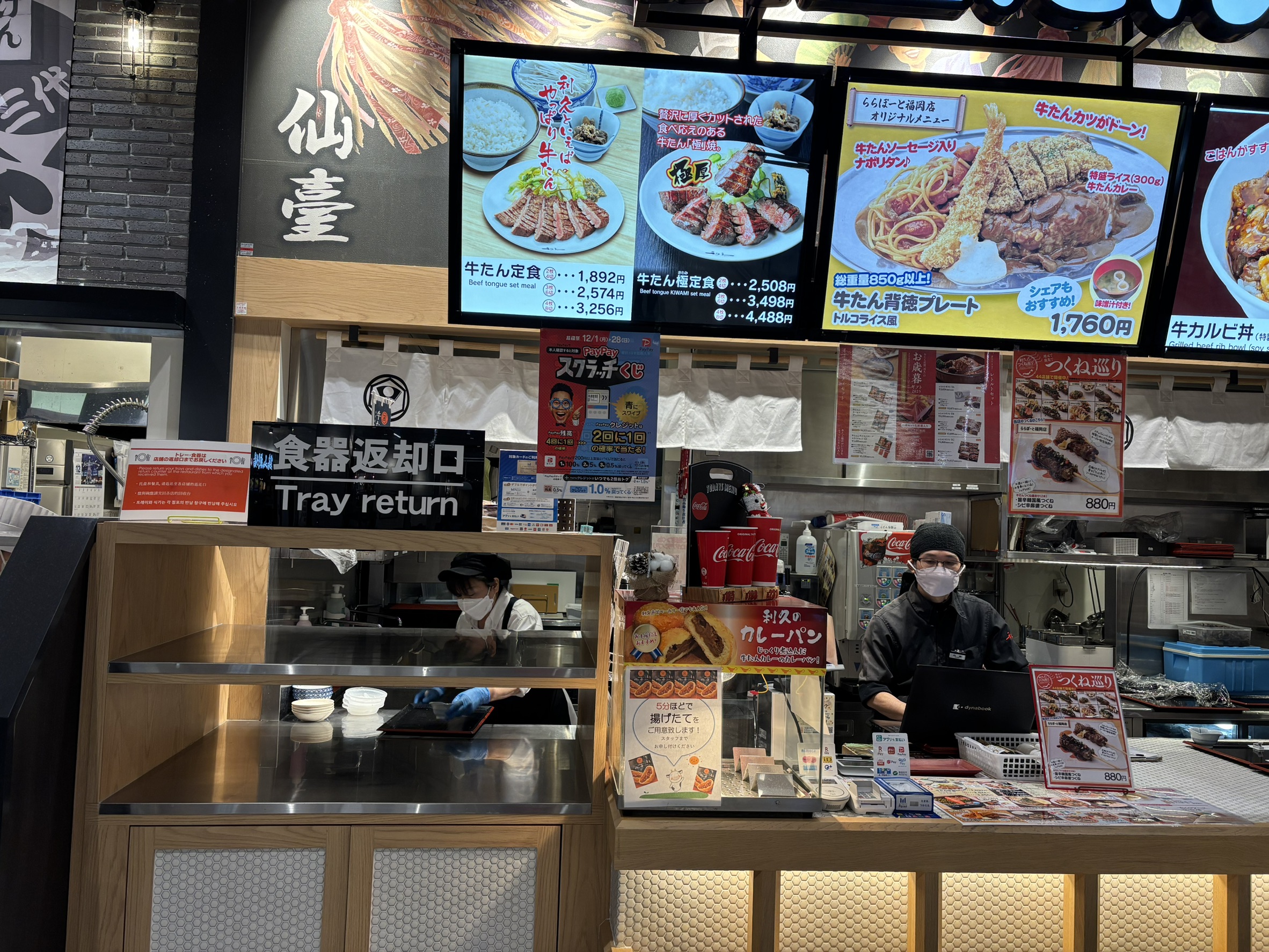 福岡 LaLaport 美食街的餐具回收口（Tray Return）。清晰的 「食器返卻口」 雙語標示與便利的地理位置，讓主動回收餐具成為直覺且不費力的行為。